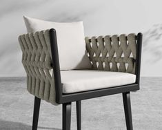 an upholstered chair with a white cushion and black legs on concrete flooring