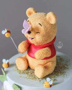 a winnie the pooh cake is decorated with honeybees