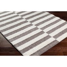 a gray and white rug on top of a wooden floor