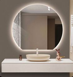 a white sink sitting under a round mirror