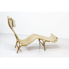 a wooden chaise lounge chair sitting on top of a white floor