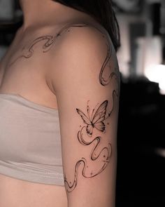 a woman with a butterfly tattoo on her left arm and right arm behind her back