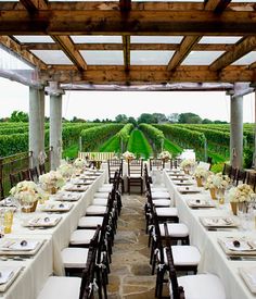 an outdoor dining area with tables, chairs and white linens set up for a formal function