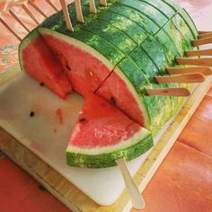 a watermelon cut in half with toothpicks sticking out of the top