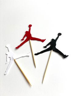 three matchsticks shaped like the air jordan basketball player, one red and one black