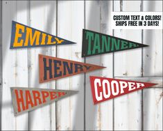 an assortment of colorful pennants hanging on a white wooden fence with the word family printed on them