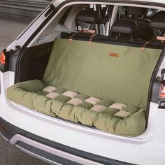 the back end of a white car with an open trunk and seat cushion on it