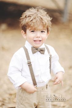 a young boy wearing suspenders and a bow tie