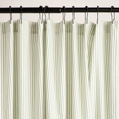 green and white striped curtains hanging on a black rod