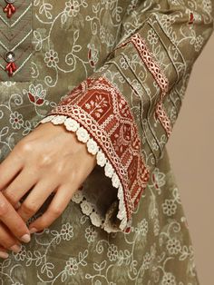 a close up of a person's hand wearing a dress with lace on it