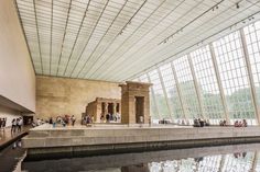 the interior of a museum with people standing around and looking at something in the water