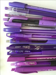 a pile of purple pens sitting on top of each other