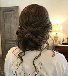 the back of a woman's head with her hair in a low bun and bride t - shirt