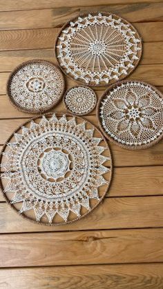 four crocheted doily plates on a wooden surface