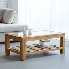 a coffee table sitting in front of a couch with a cup on top of it