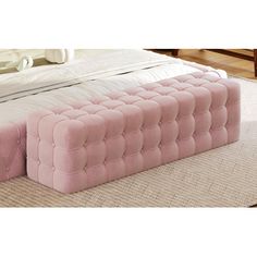 a large pink bed sitting on top of a wooden floor