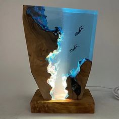 a glass vase with an image of people swimming in the water on top of it