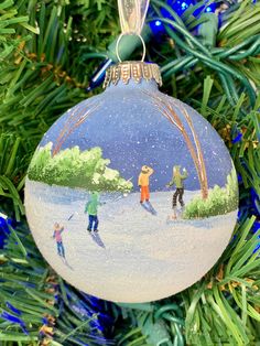 an ornament hanging from a christmas tree decorated with people skiing and snowboarding