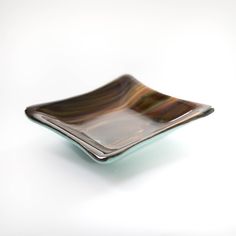 a brown and black plate sitting on top of a white table