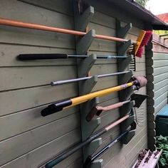 there are many different types of baseball bats hanging on the side of this house,