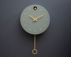 a clock that is on the side of a wall with gold hands and two circles