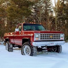 a red truck is parked in the snow