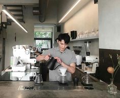 a man pouring coffee into a white cup