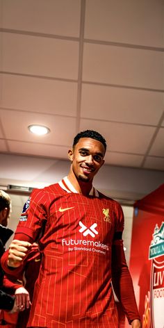 a man in a red uniform is smiling at the camera