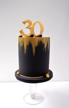 a black and gold cake with the number thirty on top