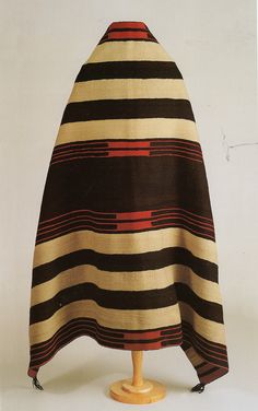 a brown and black striped cape on a wooden stand