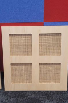 a close up of a wooden headboard on a carpeted floor with red and blue walls in the background