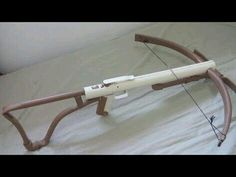 an archery bow laying on top of a bed