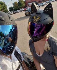 two people wearing helmets are sitting on a motorcycle