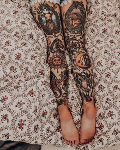 a person with tattoos on their legs laying in bed