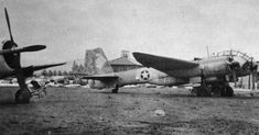 an old black and white photo of two fighter jets on the ground with other planes in the background