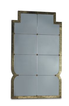 a mirror that is sitting on top of a white wall with gold trimmings