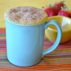 there is a powdered sugar on the top of a mug next to strawberries