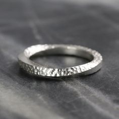 A solid, recycled sterling silver ring, with a twist. Square silver wire is twisted to form a variation of a Möbius strip, where a strip is twisted 180 degrees and joined in a loop. The twist allows you, if you follow the surface around the continuous shape from a starting point, to travel around the inside, and outside, back to where you started. Each ring is made, & textured by hand, so will differ ever so slightly from each other. One face on this ring band is heavily textured all around, whi Mobius Jewelry, Möbius Strip, Moebius Strip, Mobius Ring, Alternative Wedding Bands, Ring Shank, Detailed Ring, Twist Ring, Unisex Ring