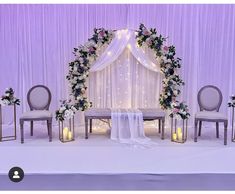 a wedding ceremony setup with candles and flowers on the table, along with two chairs