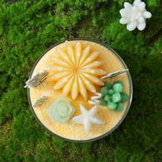 an overhead view of food in a bowl on the ground with green grass and flowers