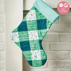 a green and white christmas stocking hanging on a brick wall