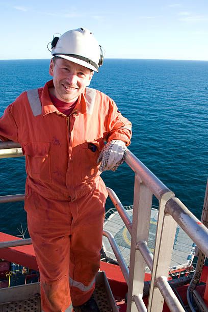 Portraits of man in orange jumpsuit on an oil rig Drilling Engineering Oil Rig, Oil Rig Engineer Scammers, Rig Engineer Pictures, Oil Rig Engineer Man, Oil And Gas Engineer, Oil Drilling Rigs Pictures, Oil Rig Pictures, Oil Rig Scammer Pictures, Oil Rig Scammers Pictures