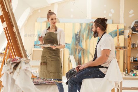 Young Woman Painting Portrait in Studio by seventyfourimages. Portrait of young woman painting picture on easel while working in sunlit art studio with bearded man sitting on chai... #Sponsored #young, #seventyfourimages, #painting, #woman Painter Photography, Couple Sketch, Art Studio Design, Couple Painting, Artist Aesthetic, Woman Painting, Pictures To Paint, Artist Painting, Couples Photoshoot