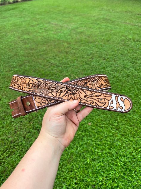 Hand tooled sunflower/feather belt with initials at the end Leather Belt Designs, Tooled Sunflower, Feather Belt, Belt Ideas, Custom Belts, Custom Leather Belts, Tooled Leather Belts, Tooling Patterns, Leather Craft Patterns