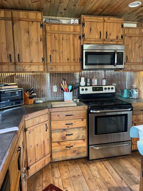 Rustic meets industrial in this kitchen. Pictured: Galvalume ceiling tiles. Farmhouse Kitchen Rustic Cabinets, Rustic Kitchen Cupboard Doors, Barn Tin Kitchen Island, Galvalume Ceiling, Rustic Pine Kitchen Cabinets, Burnt Wood Cabinets, Rustic House Remodel, Corrugated Metal Wall Kitchen, Rustic Kitchen Cabinet Doors