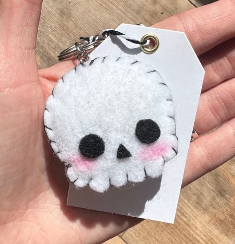 Handmade felt skull keychain with blushing cheeks. All items are hand-sewn by Alice's Felt Creations. All items are also made to order and can be customized by request. Thank you for supporting my small business! Kuromi Felt Pattern, Diy Felt Crafts To Sell, Felt Keychain Diy, Things To Make With Felt, Felt Hello Kitty, Felt Skeleton, Felt Sewing Projects, Felt Charms, Sewn Keychain