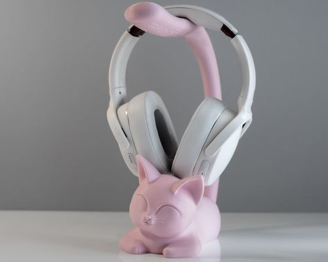 "Say Hello to our adorable feline friend, the Purrfect Headphone Display Holder! It's the perfect gift for cat and music lovers, gamers or anyone who could use a little extra charm in their life.  With its pawsitively cute design, this cutie cat is ready to lend a helping paw. Just hang your headphones over its tail, and voila! No more mess when looking for your headphones before your Zoom call or gaming session. It's like having a personal assistant, but without the sassy attitude! 💡 Little Ki Clay Headphone Holder, Headphone Holder Diy, Headphone Display, Headphones Holder, Headphone Decoration, Headphones Stand, Sassy Attitude, Room Decor Cute, Cutie Cat