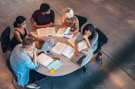 Mixed race students sitting at table with books and laptop studying together. Study Tips For High School, Tips For High School, People Studying, Studying Together, Study Strategies, Health And Wellness Center, Technology Photos, Group Study, Business Degree