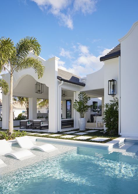 Three modern white pool loungers line a Baja pool ledge. Florida Mediterranean House, Coastal Modern Architecture, Coastal Modern Beach House, Modern Florida Beach House, Beach House Design Exterior Coastal Homes, Palm Beach Exterior Home, Coastal Florida Home, Mediterranean Coastal Style, Dream Florida Home