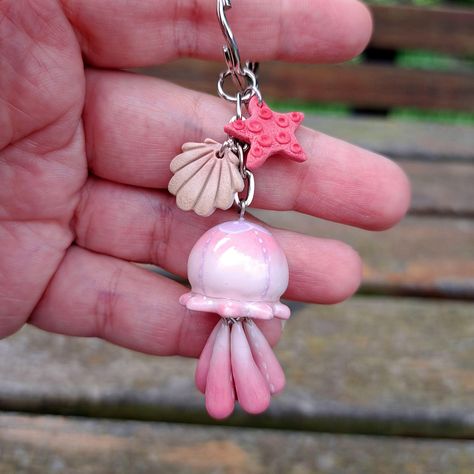 Carry a piece of ocean everywhere you go with this unique jellyfish keychain!  Every piece is lovingly hand crafted with polymer clay and painted with tiny lovely details. The color is protected with a coat of resin to make it even more durable. Infused with its own unique character and charm, this keychain is the perfect touch of ocean magic for your everyday life or for a special gift. Measures are around: Jellyfish  3.5 x 2 cm   ( 1.38 " x 0.79" inches ) Keychain Total Lenght  8.5 cm   ( 3.35 Charms For Keychains, Jellyfish Polymer Clay, Air Dry Clay Jellyfish, Polymer Clay Jellyfish, Cute Clay Keychains, Ceramic Jellyfish, Brain Keychain, Clay Keychain Ideas, Whale Clay